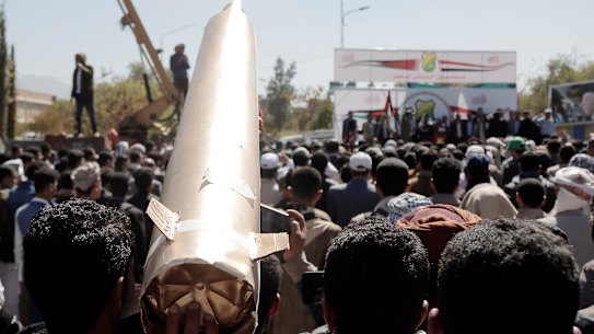 A Yemeni in Sanaa protester lifts a mock missile while participating in a protest staged against the US-led sustained airstrikes on Yemen.