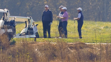 President Donald Trump, left, plays golf.