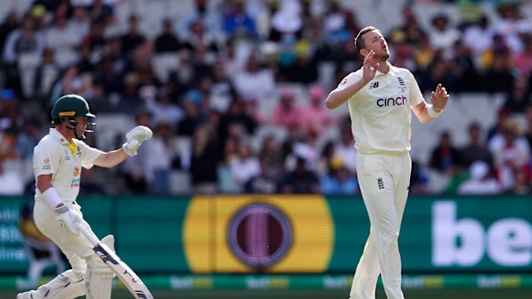 Ollie Robinson bowls as Marcus Harris looks on. 