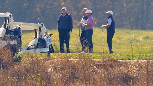President Donald Trump, left, plays golf.