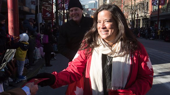 Veterans Affairs Minister Jody Wilson-Raybould, right, hands out lucky red envelopes during a Chinese New Year Parade in Vancouver on Sunday.
