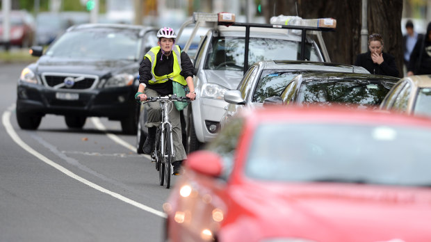 A cyclist negotiates traffic on busy St Kilda Road.