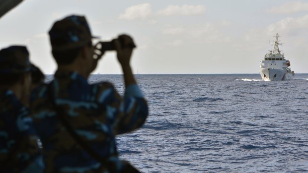 Vietnamese sailors watch the approach of a Chinese coast guard vessel near the Paracel Islands.