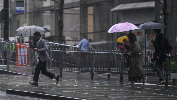 Pedestrians bust out the brollies as heavy rain hits Melbourne on Friday afternoon.