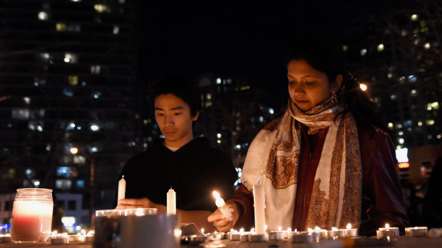 People light candles at a makeshift memorial to the victims in Toronto..
