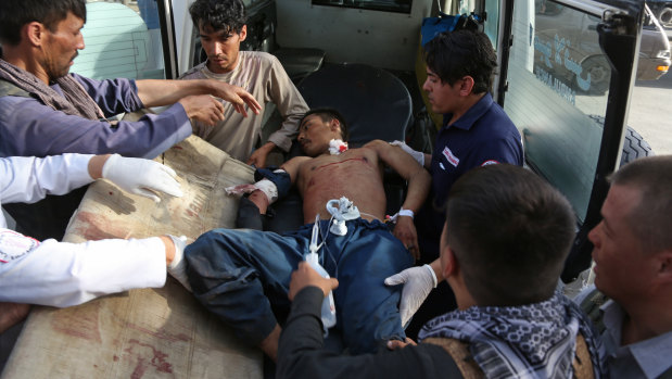 A man injured in the bombing in the Shiite neighbourhood of Dasht-i Barcha is placed in an ambulance.