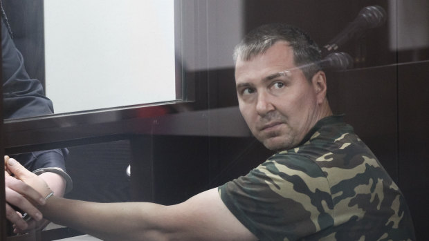 Alexander Popov, a man who was arrested on suspicion of murder sits behind the glass in a courtroom in the city of Gorodets, 60 km north-west of Nizhny Novgorod, Russia. 