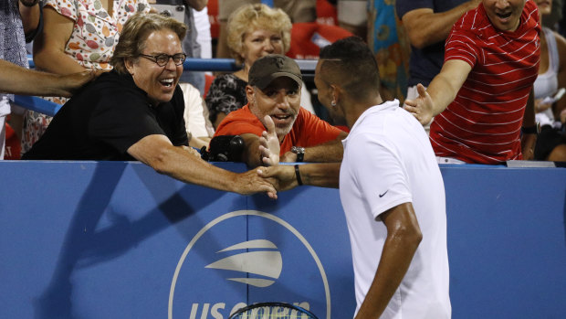Man of the people: Kyrgios celebrates with a random fan after his victory.