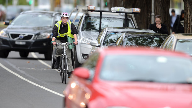 A cyclist negotiates traffic on busy St Kilda Road.