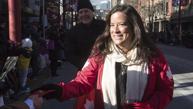 Veterans Affairs Minister Jody Wilson-Raybould, right, hands out lucky red envelopes during a Chinese New Year Parade in Vancouver on Sunday.