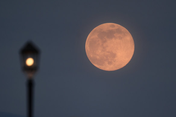 The supermoon rises over Worthing pier in Worthing, UK.