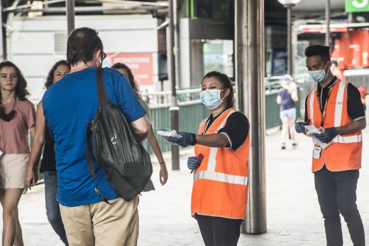 Masks are handed out at Circular Quay in Sydney.