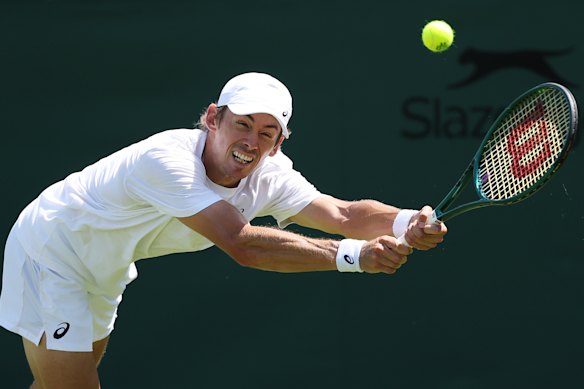 De Minaur stretches for a ball in practice.
