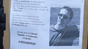 A portrait of slain teacher Samuel Paty is displayed during a demonstration in Paris on Sunday.