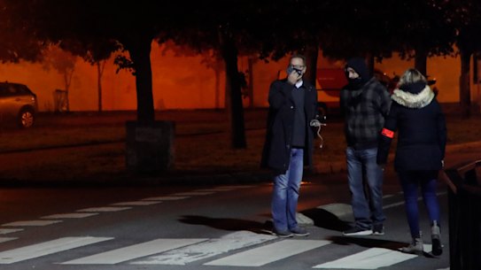 French police officers gather at the scene of the teacher's death in Conflans Sainte-Honorine.