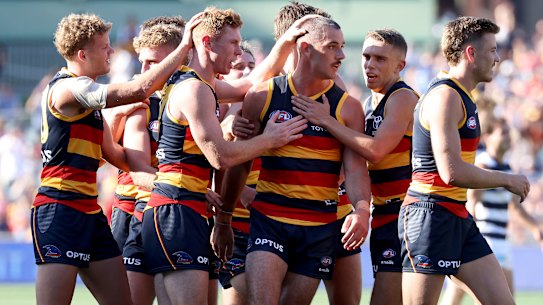 Taylor Walker is congratulated by teammates after scoring in the Crows’ win over Geelong.
