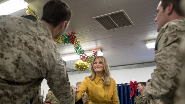 First lady Melania Trump talks with troops at a dining hall.