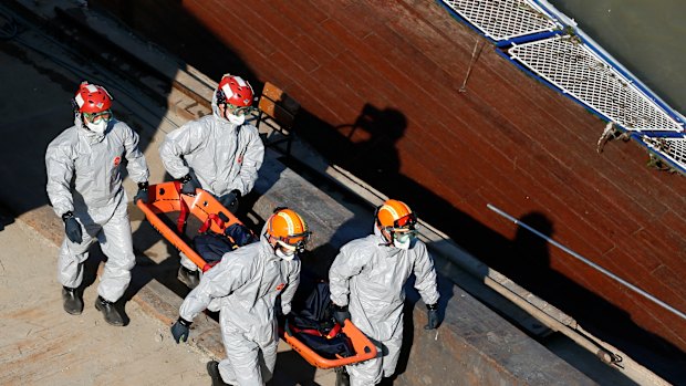 Members of a South Korean rescue team carry a body from the sightseeing boat after it was lifted out of Danube River on Tuesday.