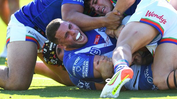 Adam Elliott is held over the line in the Bulldogs’ loss to the Warriors.