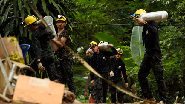 Thai army soldiers carry oxygen cylinders out of the cave on Saturday.