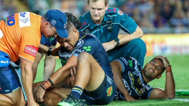 Play on: Cowboys duo John Asiata (left) and Nene Macdonald are attended to after their brutal collision last Friday night.