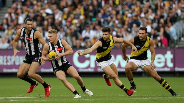 Adam Treloar of the Magpies (2nd left) gets away from Trent Cotchin of the Tigers (2nd right) during the Round 6 AFL match between the Collingwood Magpies and the Richmond Tigers at the MCG in Melbourne, Sunday, April 29, 2018.