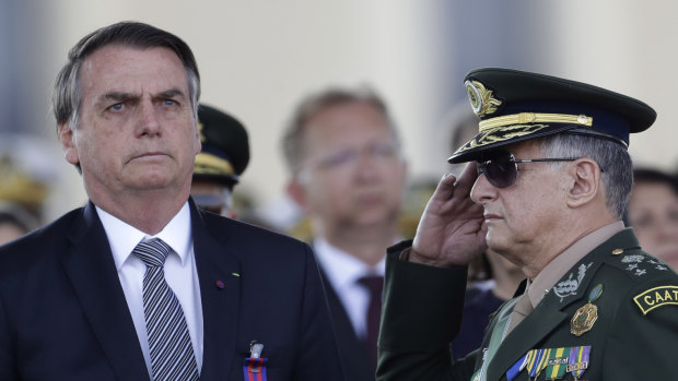 Brazil's President Jair Bolsonaro, left, receives military honours on Friday.