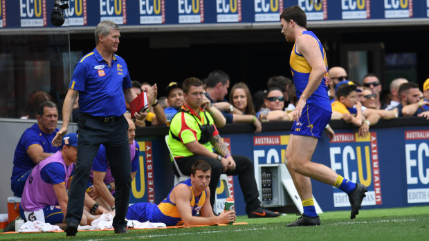 West Coast defender Jeremy McGovern leaves the field for treatment.