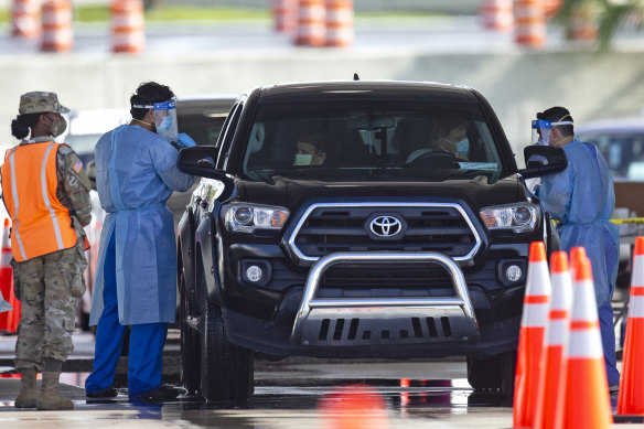 People are tested for COVID-19 at a drive-through testing centre at Hard Rock Stadium in Miami Gardens. 