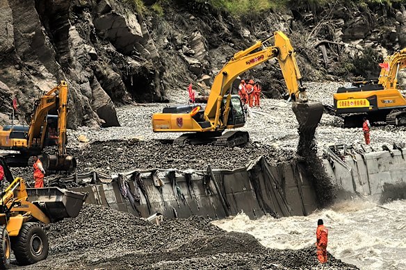 Rescuers use heavy machines to clear a road leading to the mudslide-hit areas in Xigaze, Tibet.