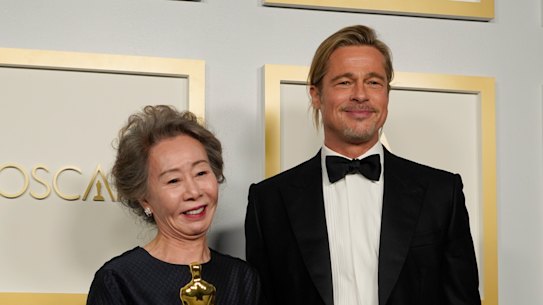 Best actress in a supporting role winner Yuh-Jung Youn poses in the press room with Brad Pitt.