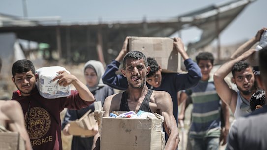 Palestinians with boxes of humanitarian aid collected from a distribution centre in the Netzarim Corridor, central Gaza Strip, on Thursday.