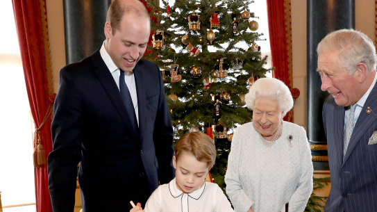 Prince William, Duke of Cambridge, Prince George, Queen Elizabeth II and Prince Charles, Prince of Wales prepare special Christmas puddings in the Music Room at Buckingham Palace.