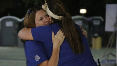 Volunteers Denise Buessing, left, and Marsha Struzik embraces following a deadly shooting at the Gilroy Garlic Festival in California on Sunday.