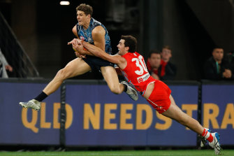 Charlie Curnow takes a mark in front of Tom McCartin of the Swans.