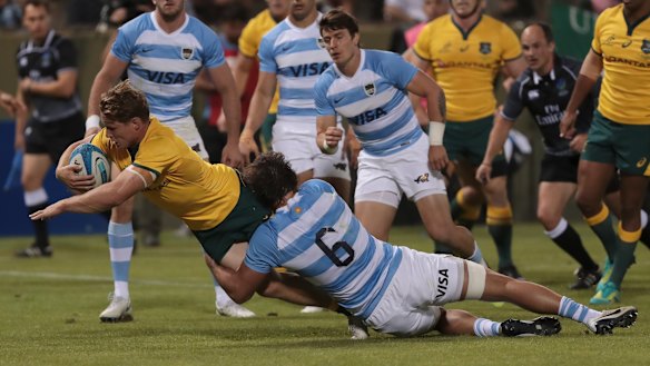 Try time: Michael Hooper forces his way over despite best efforts from Puma Pablo Matera.