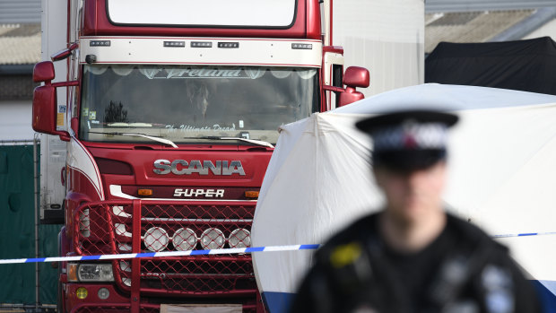 Police stand guard at the site where 39 bodies were discovered in a lorry.
