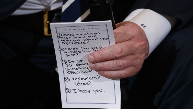 President Donald Trump holds notes during a listening session with those affected by the Parkland shooting.