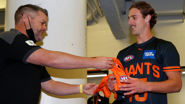 Adam Schneider presents GWS debutant James Peatling with his jumper earlier this month.