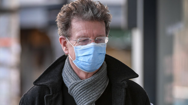 Former ABC radio host Red Symons wears a mask on Lygon Street in Carlton.