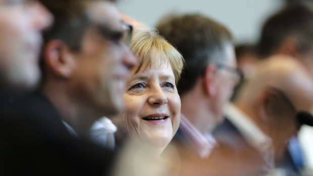German Chancellor Angela Merkel smiles as she attends a faction meeting of the Christian Union parties, the Christian Democratic Union, CDU, and Bavarian's Christian Social Union, at the Reichstag building in Berlin, on Monday.