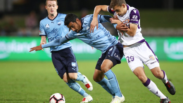 Arm in arm: Reza Goochannejhad tangles with Perth's Jake Brimmer in Sydney's 1-0 win.