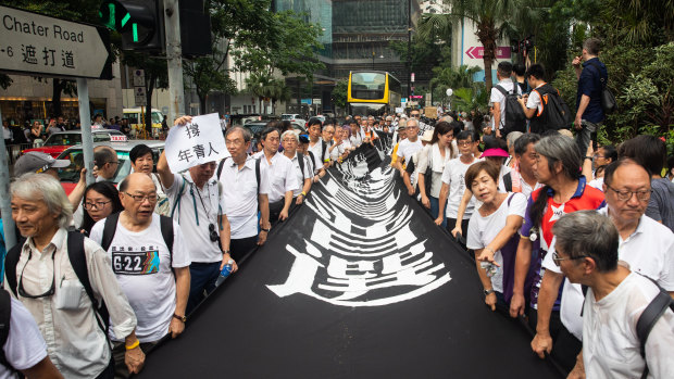 Demonstrators carry a banner during a protest organised by the elderly in the central district of Hong Kong.