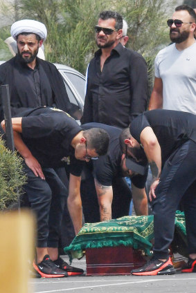 Nabil Maghnie's sons stand over his coffin at the underworld figure's funeral last week.