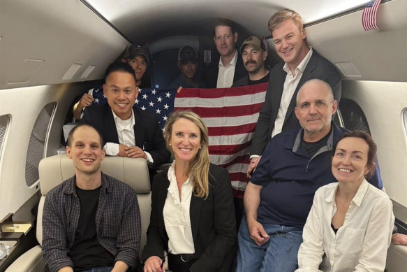 Evan Gershkovich, left, Alsu Kurmasheva, right, Paul Whelan, second from right, and others aboard a plane home after being freed.