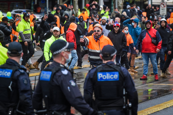 Police and protesters face off out the front of the CFMEU office on Elizabeth Street on Monday. 