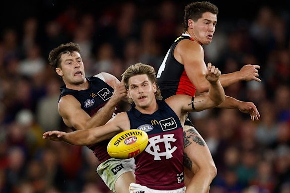 (L-R) Josh Dunkley of the Lions, Will Ashcroft of the Lions and Liam Stocker of the Saints compete for the ball.