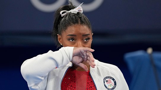 Simone Biles watches on after she exited the team final.