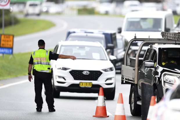 Vehicles arriving from NSW queue at a police checkpoint at the Queensland-NSW border in Coolangatta.