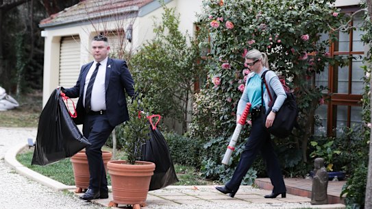 AFP officers depart after the raid on the home in Canberra.